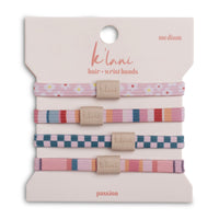 Set of four patterned hair ties with logo tags on retail packaging card, medium size