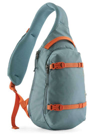 Single-strap sling bag in teal with orange buckles and compression straps, side angle view