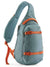 Single-strap sling bag in teal with orange buckles and compression straps, side angle view