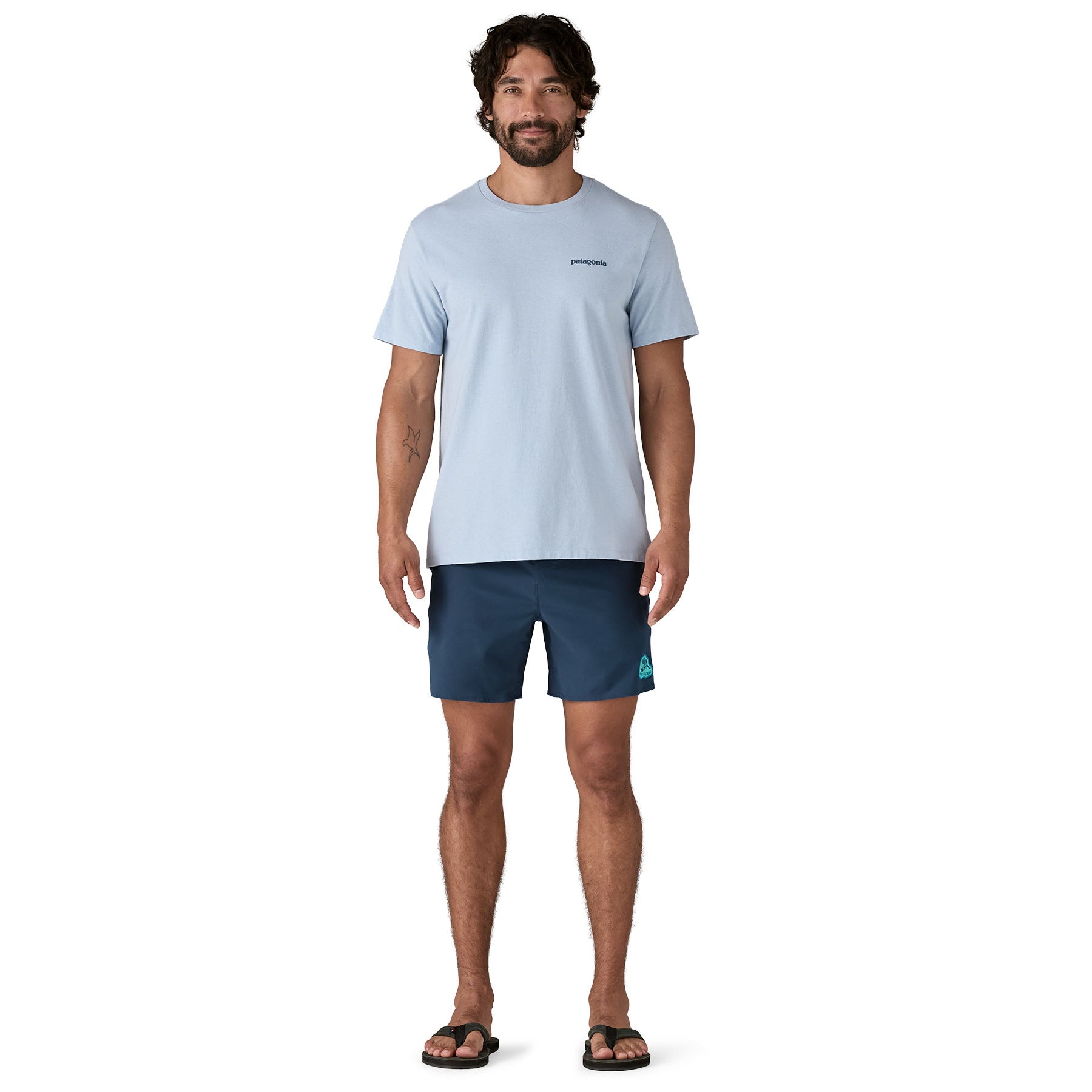 Dark navy blue men's swim shorts with side logo, worn by model standing front view