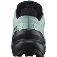 Trail running shoe rear view showing aqua green upper, black lugged outsole, and ankle collar