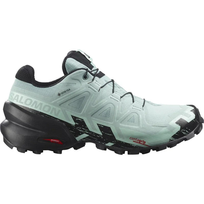 Women's trail running shoe in mint green and black with aggressive lug outsole, lateral view