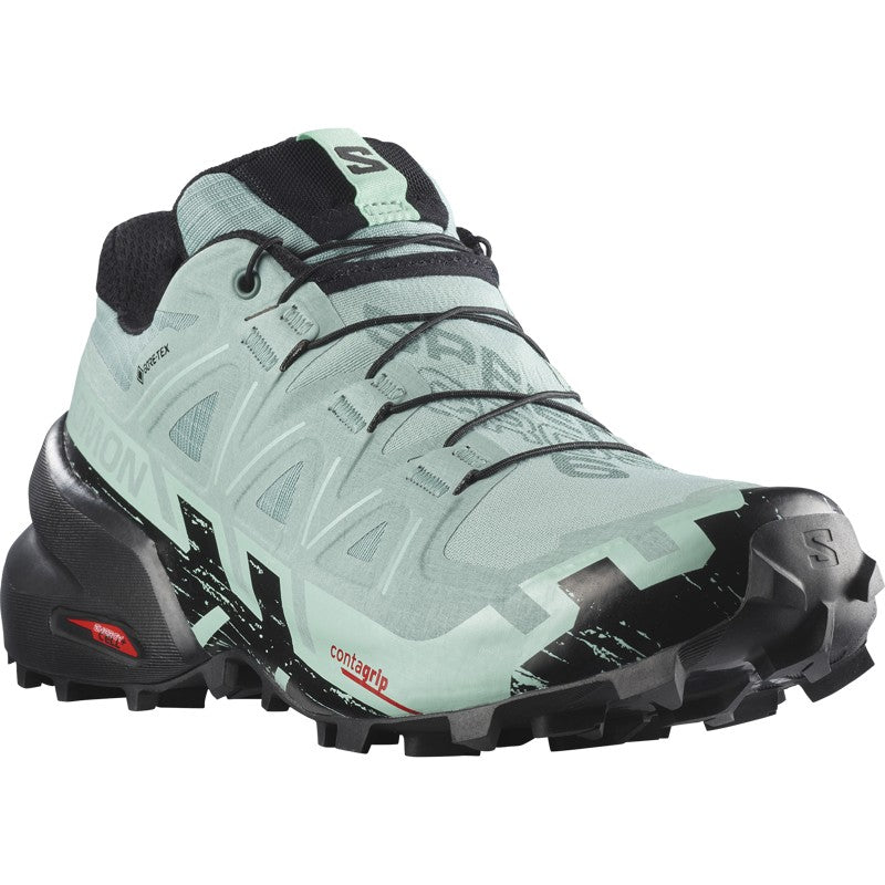 Women's trail running shoe with mint green upper, black aggressive lug outsole, and Gore-Tex waterproof construction