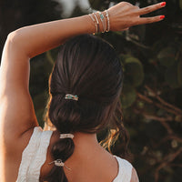 Hair tie and bracelet set with silver metallic bands and turquoise stones, styled in braid