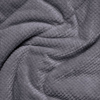 Close-up detail of a soft textured fleece blanket with waffle-knit pattern in dark grey