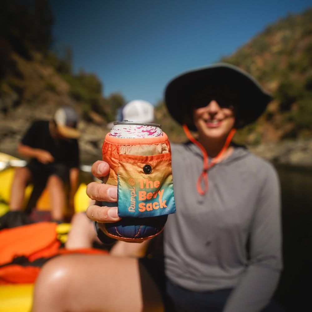 Hand holding a colorful gradient can koozie on a river rafting trip outdoors