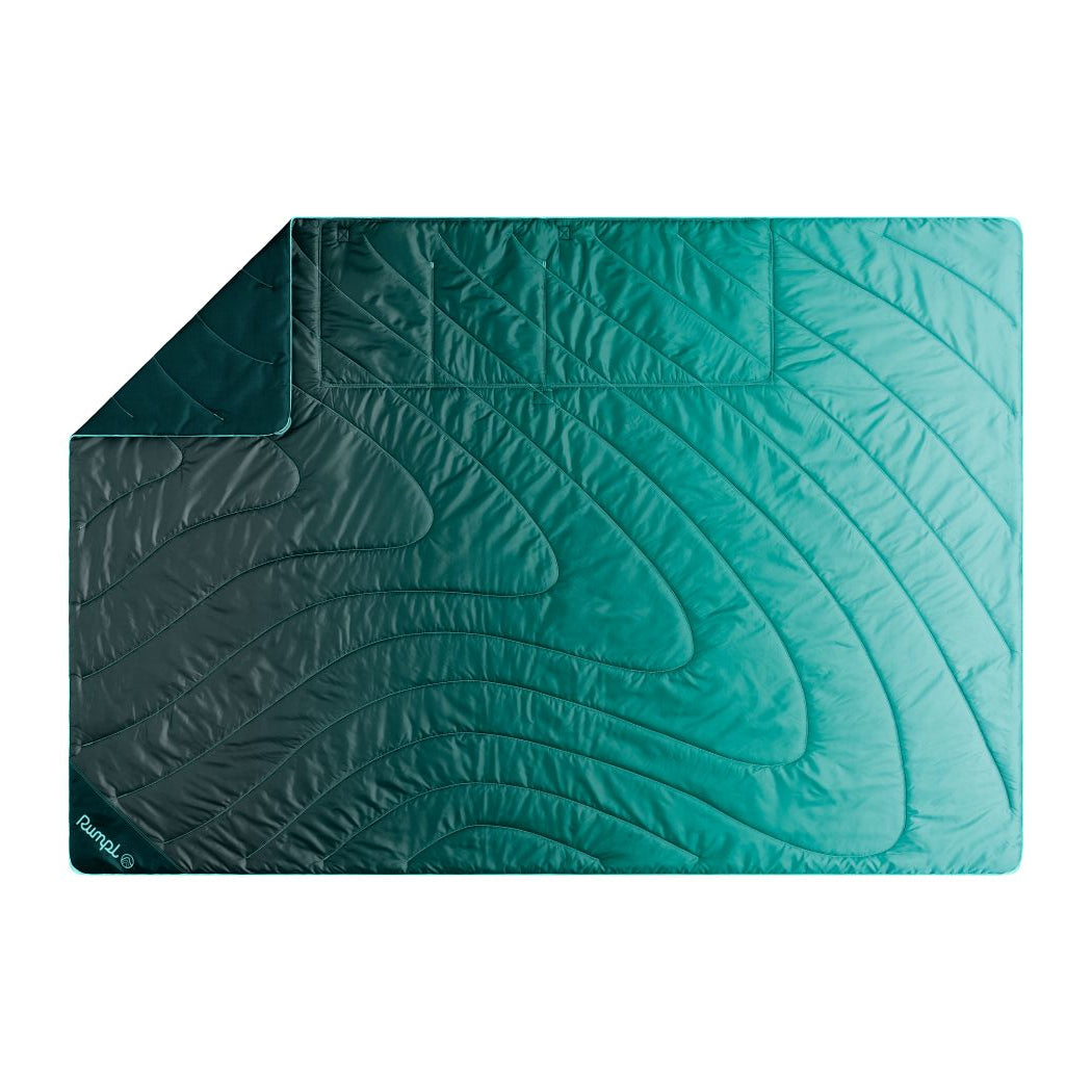 Quilted outdoor mat with curved wave pattern in gradient teal colors, flat lay view
