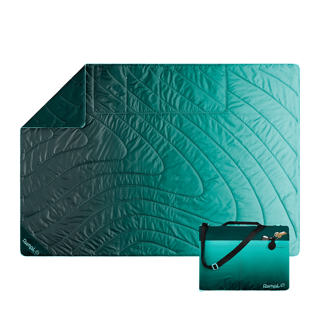 Quilted outdoor mat with gradient teal to green fade pattern and matching compact carrying case