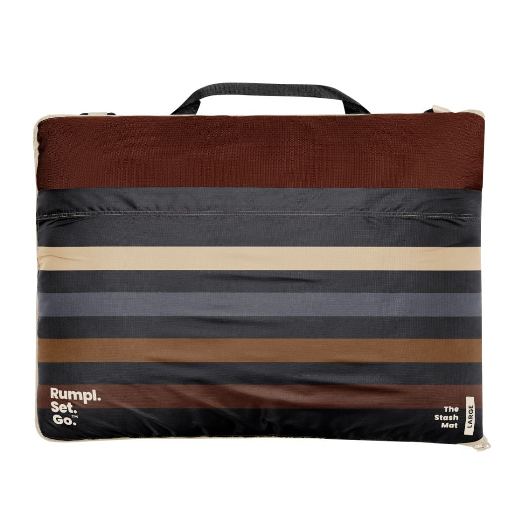 Striped outdoor mat with carrying handle in brown gray and cream tones
