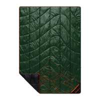 Green quilted outdoor blanket with orange mountain topographic pattern and black corner folded back