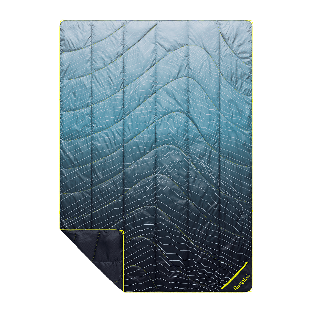 Quilted outdoor blanket with blue gradient pattern and white wavy lines, shown flat