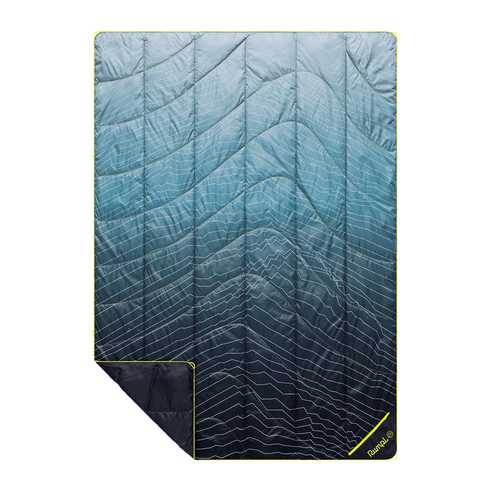 Quilted outdoor blanket with blue gradient pattern and white wavy lines, shown flat