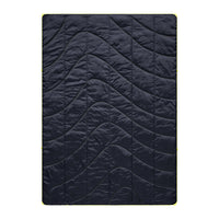 Dark blue quilted camping blanket with curved wave pattern stitching, flat overhead view