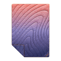 Quilted puffy blanket with gradient fade pattern from coral to navy, shown folded with corner detail
