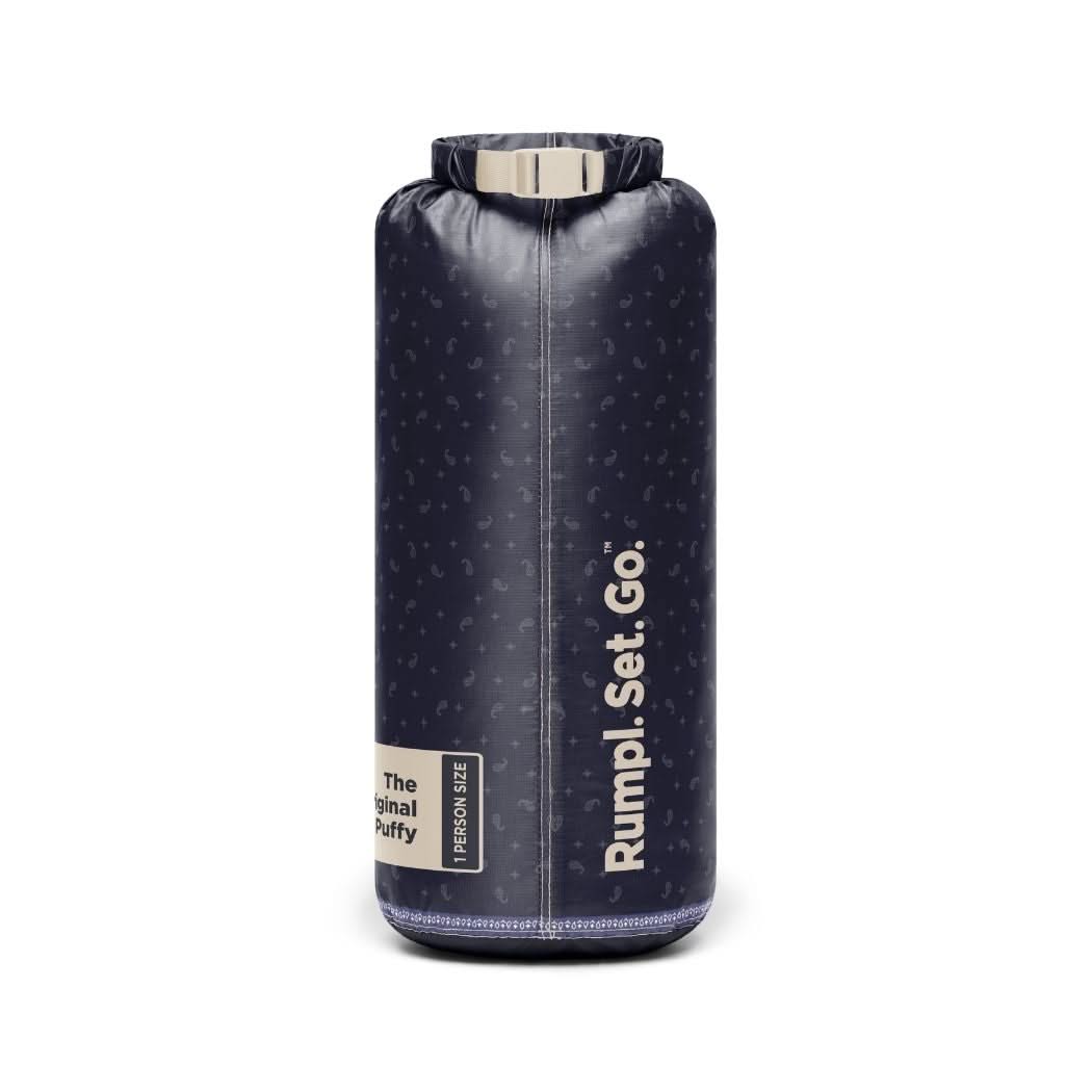 Navy puffy blanket rolled and packed into a cylindrical dry bag with roll-top closure