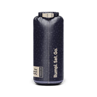Navy puffy blanket rolled and packed into a cylindrical dry bag with roll-top closure