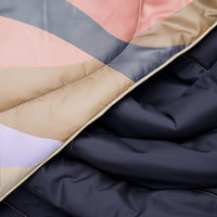 Folded puffy blanket with geometric color-blocked pattern in navy, coral, beige and purple sections
