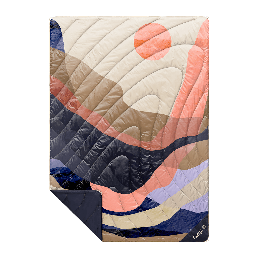 Quilted outdoor blanket with abstract curved pattern in coral, navy, cream and purple tones