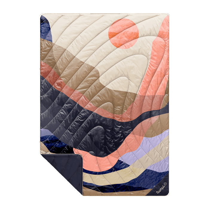 Quilted outdoor blanket with abstract curved pattern in coral, navy, cream and purple tones