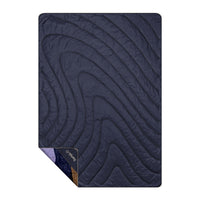 Navy blue quilted outdoor blanket with curved stitching pattern laid flat on white background