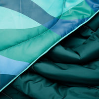 Quilted puffy blanket with teal and blue geometric pattern, showing fabric texture and stitching details
