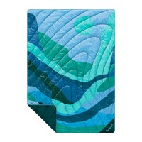 Quilted puffy blanket with blue and teal wave pattern, folded to show corner detail
