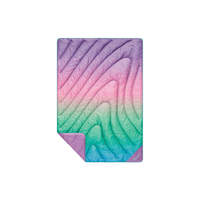 Quilted puffy mini blanket with rainbow gradient ombre pattern, corner folded to show solid purple reverse side