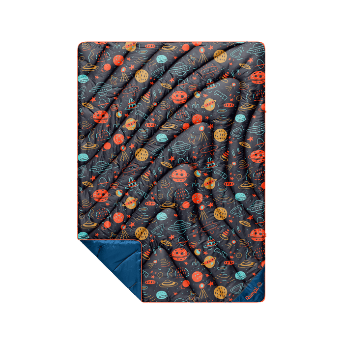 Puffy quilted blanket with space-themed doodle print, navy blue reverse side visible at folded corner