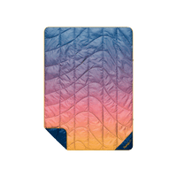 Quilted puffy blanket with sunset gradient ombre pattern, blue to orange, with navy reverse side