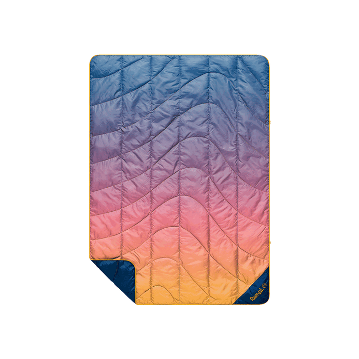Quilted puffy blanket with sunset gradient ombre pattern, blue to orange, with navy reverse side