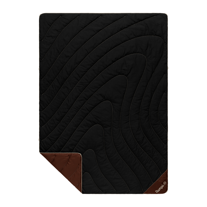 Black quilted camping blanket with diagonal stitching pattern and brown corner accents, flat lay view