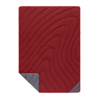 Red quilted puffy blanket with curved stitching pattern and gray corner fold showing reverse side