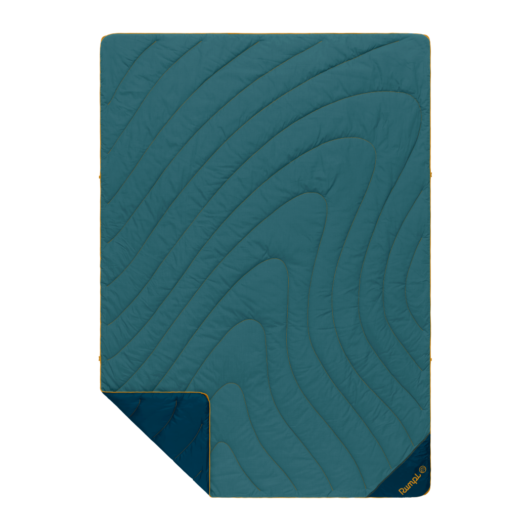 Quilted outdoor blanket with topographic swirl stitching, teal top and navy reverse, corner folded