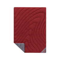 Red quilted puffy blanket with topographic swirl pattern, corner folded to reveal gray underside