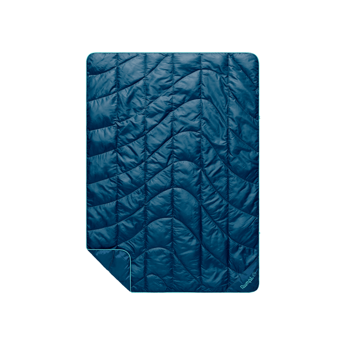 Quilted puffy travel blanket in deep teal with wave pattern stitching and folded corner