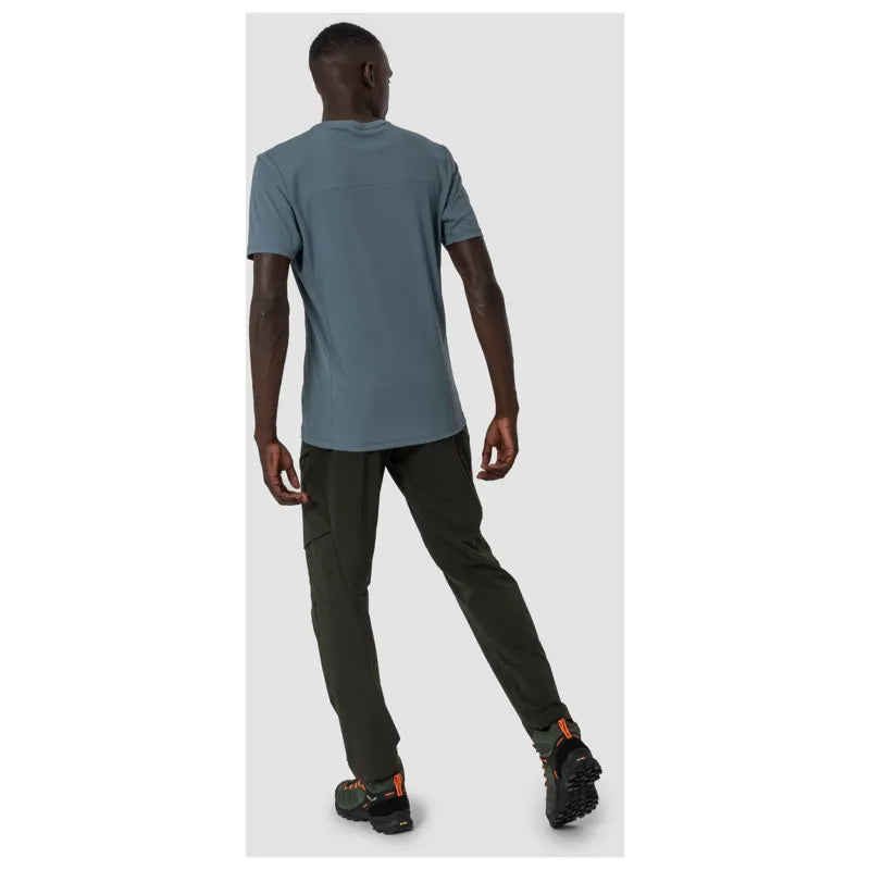Man wearing dusty blue short-sleeve athletic t-shirt with dark pants, back view