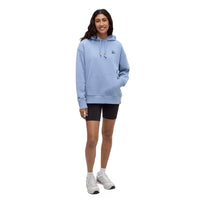 Light blue pullover hoodie with drawstrings worn by woman with black shorts and white sneakers