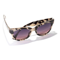 Tortoise shell patterned sunglasses with gradient purple lenses on white background