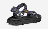 Sport sandal with navy and grey patterned straps and black rubber sole, side view