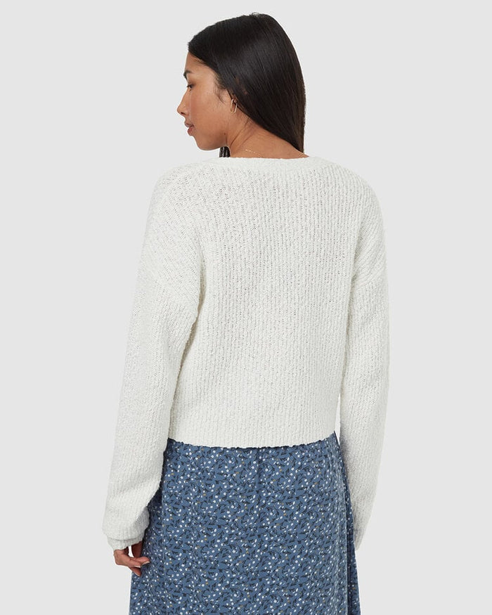 Light cream knit cardigan worn by woman, back view showing ribbed texture and relaxed fit