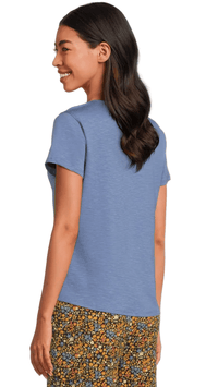 Light blue short-sleeve t-shirt shown from back three-quarter view on model with floral print pants