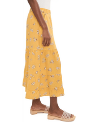 Yellow floral print palazzo pants with tiered ruffles worn with nude studded sandals