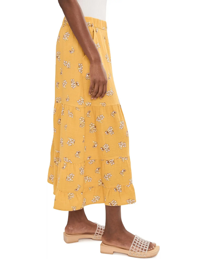 Yellow floral print palazzo pants with tiered ruffles worn with nude studded sandals