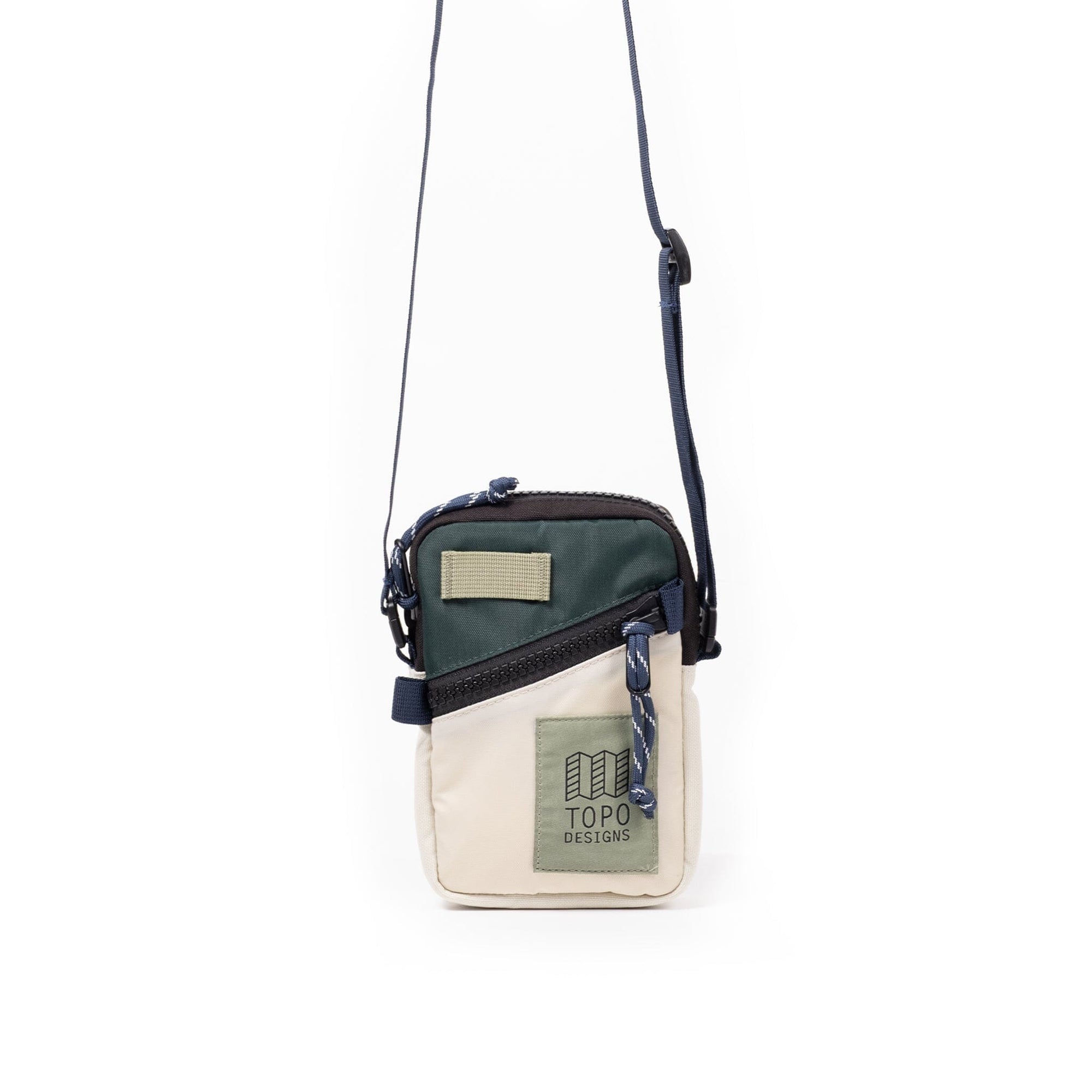 Small crossbody bag with green and cream color blocking, adjustable strap, front zipper pocket