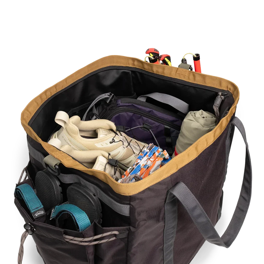Open gear bag showing packed climbing equipment including harnesses and rope with external pockets