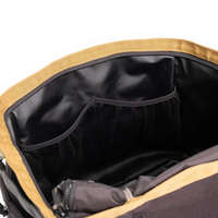 Open gear bag showing interior mesh pockets and black lining, mustard yellow exterior