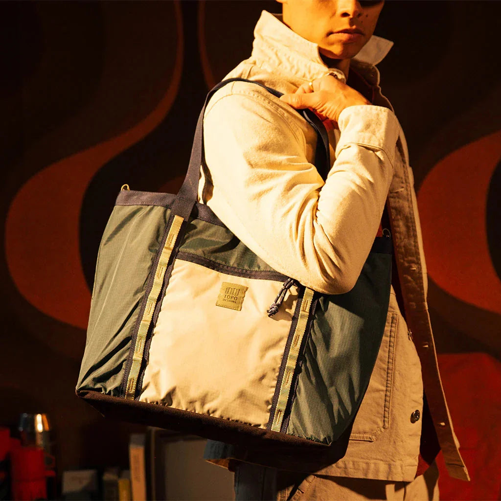 Large utility tote bag with green and cream panels, yellow straps, worn over shoulder