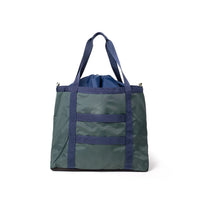 Large utility tote bag with green body, navy straps, drawstring top closure and front pocket
