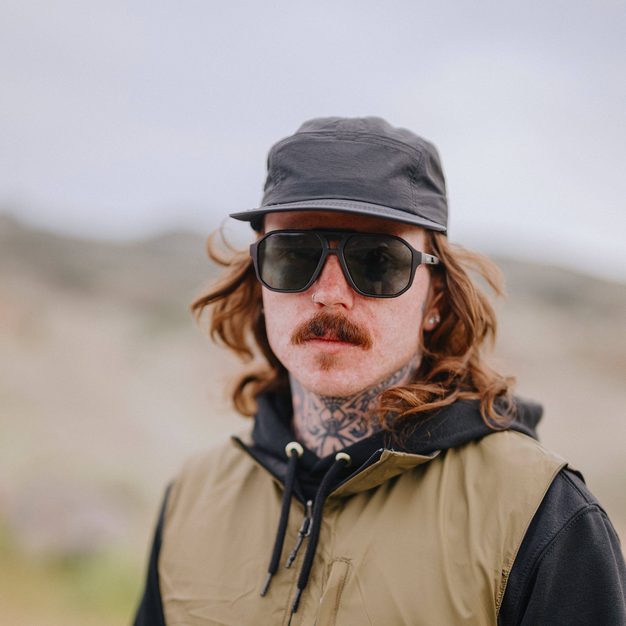 Person wearing dark sunglasses with polarized lenses in outdoor desert setting