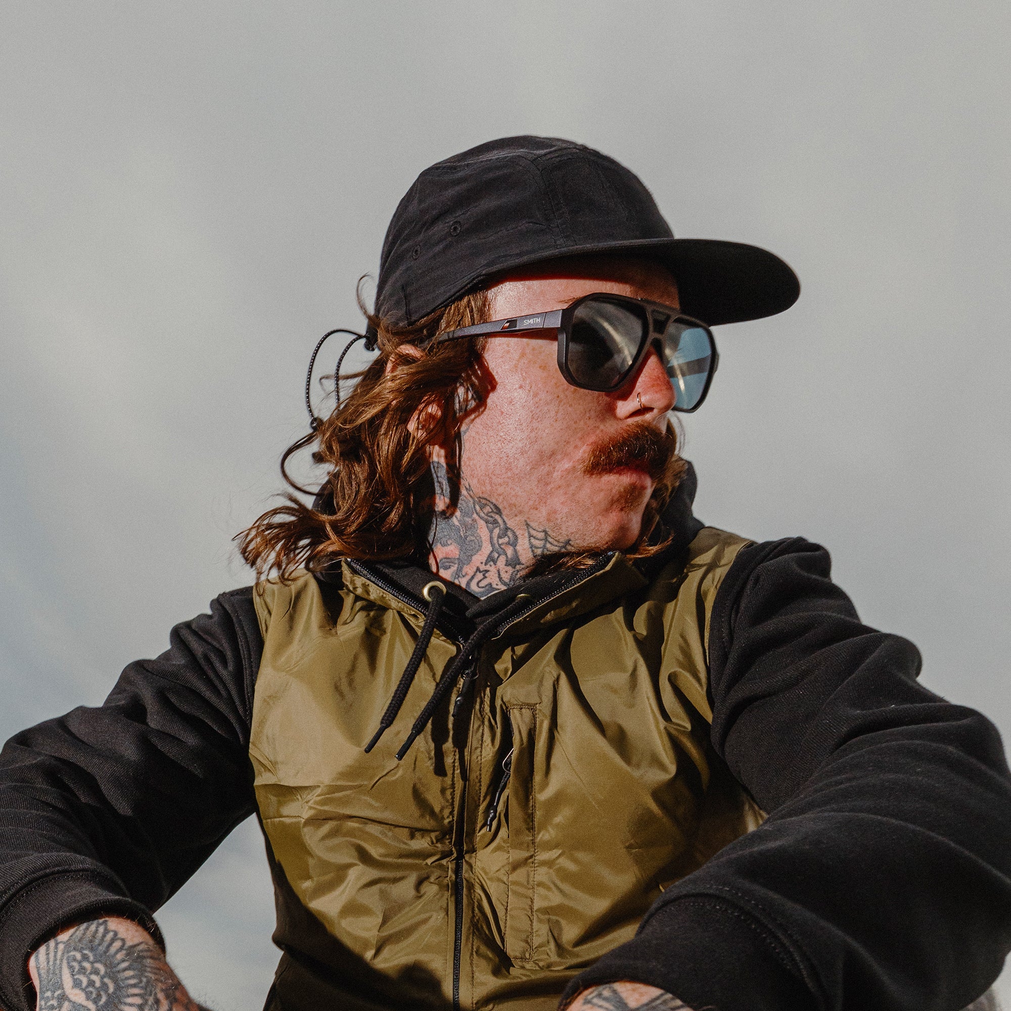 Person wearing dark framed sunglasses with polarized lenses in outdoor lifestyle setting